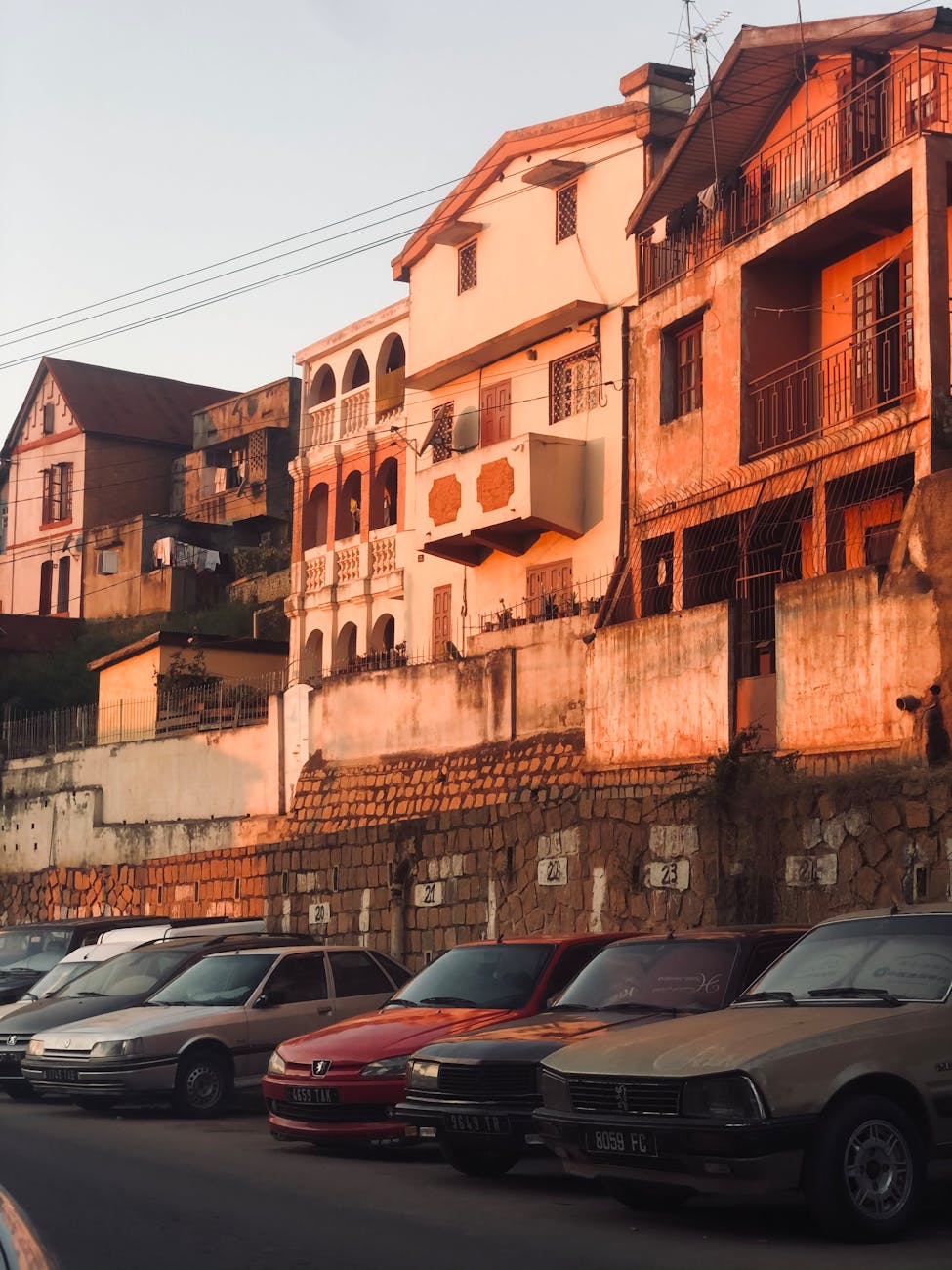 Antananarivo ao entardecer, com fachadas coloniais e carros alinhados sob a luz dourada, símbolo da transição política em Madagáscar.