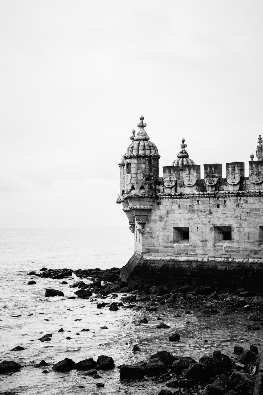 Fotografia a preto e branco da Torre de Belém, monumento histórico de Lisboa, junto ao rio Tejo.
