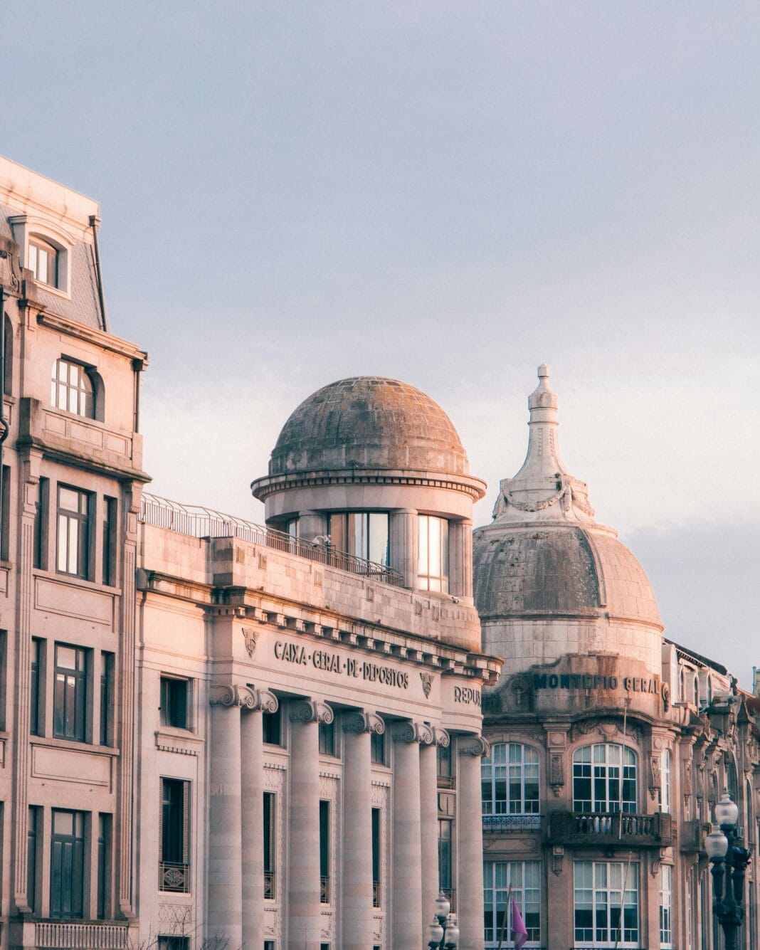 Edifícios da Caixa Geral de Depósitos e Montepio Geral no Porto ao entardecer.