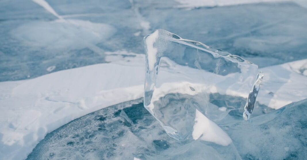 Fragmento de gelo transparente sobre a superfície gelada do Lago Baikal, simbolizando o silêncio e a resistência dos jovens russos à censura.