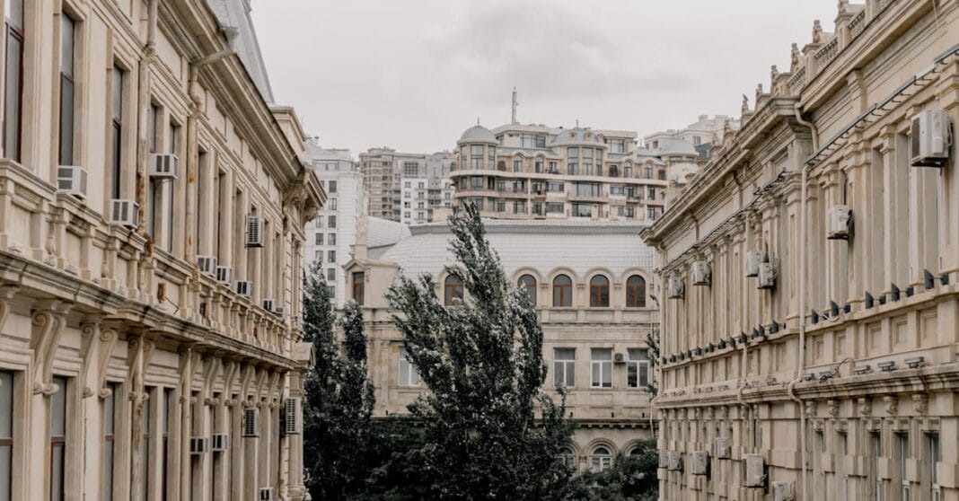 Edifícios históricos de pedra num quarteirão estreito em Londres, vistos a partir do nível da rua.