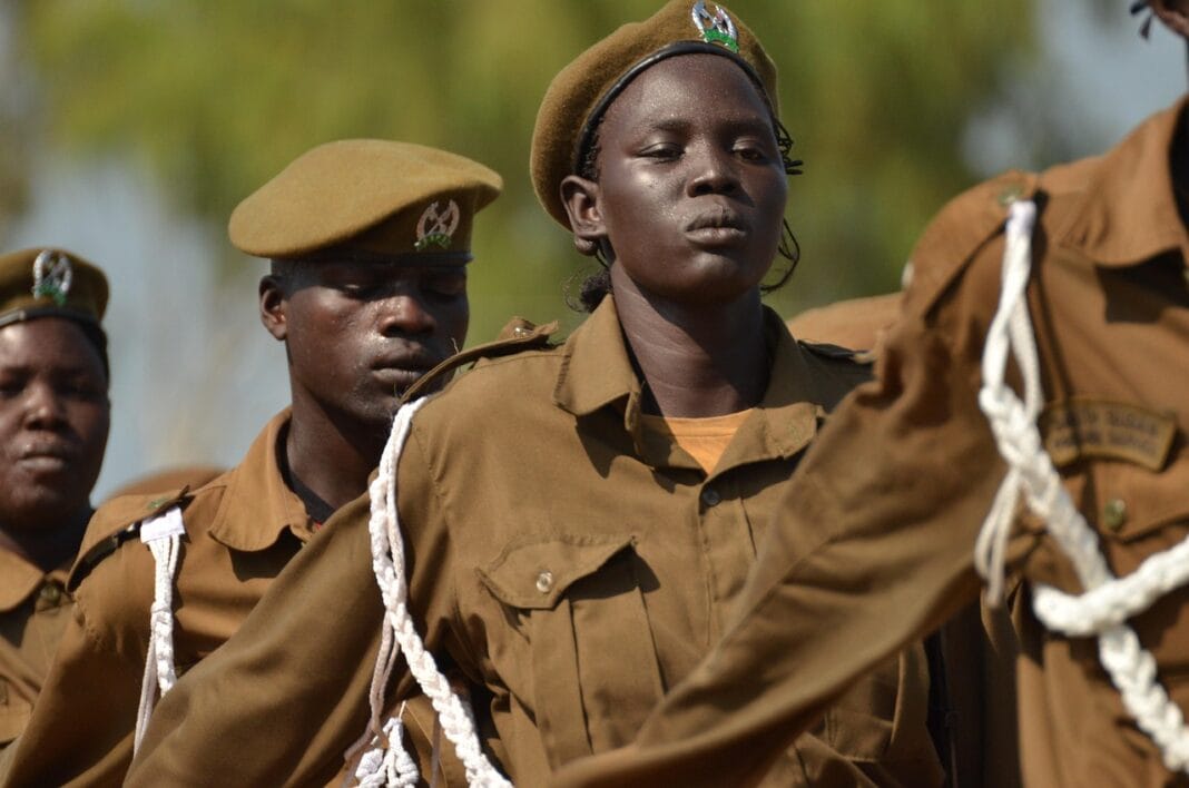 Soldados sudaneses em uniforme durante uma formação militar ao ar livre.