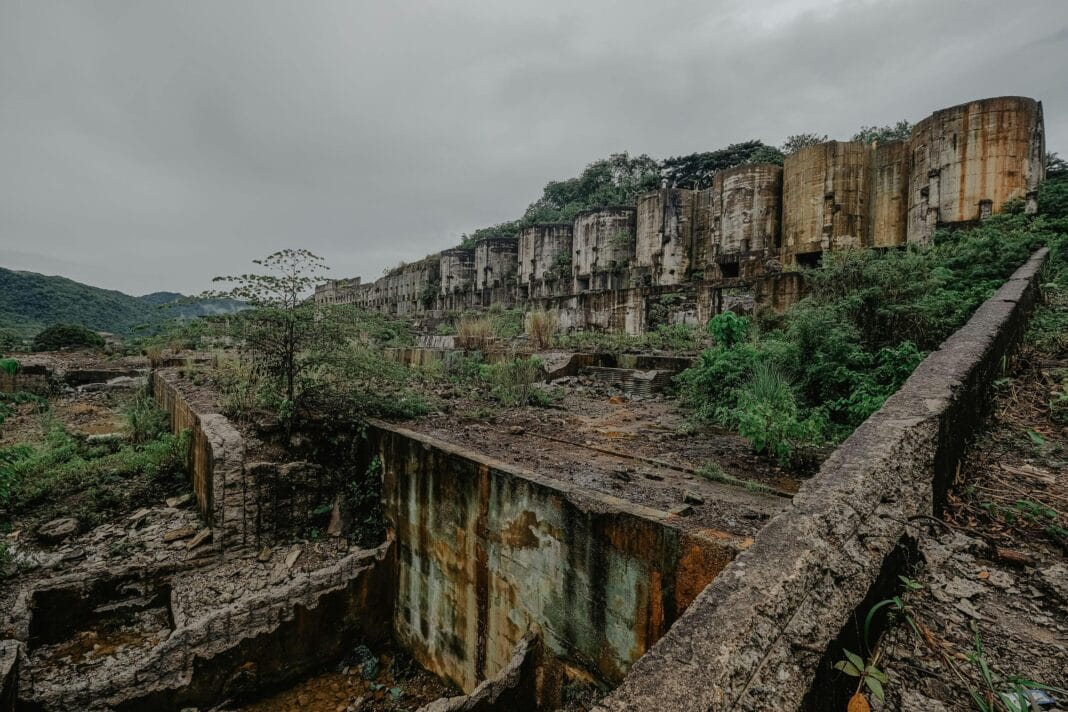 Vista aérea de uma mina a céu aberto com paredes rochosas e maquinaria ausente, ilustrando locais de extração de metais.