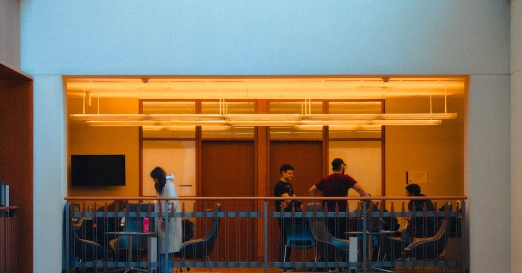 Vista interior de um edifício público com pessoas em reunião, simbolizando o debate jurídico e político sobre a cláusula “notwithstanding” no Supremo Tribunal do Canadá.