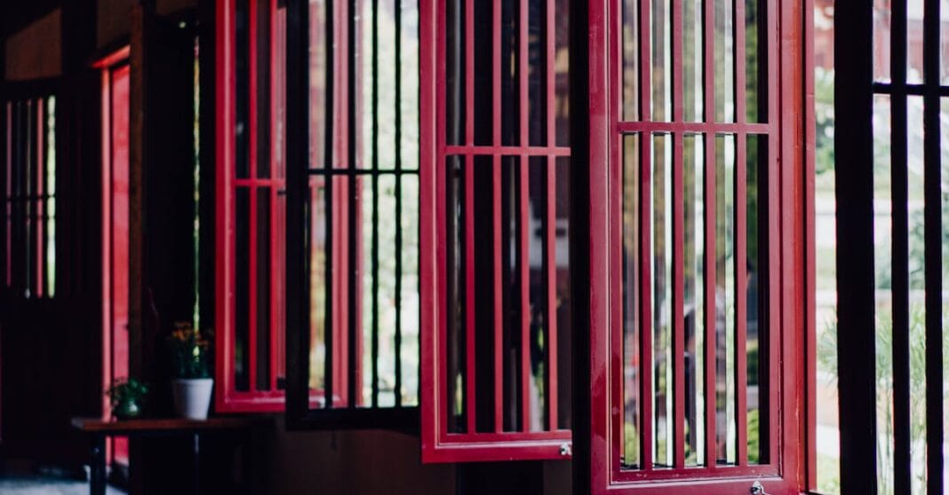 Arquitetura tradicional chinesa com janelas vermelhas abertas e interiores serenos