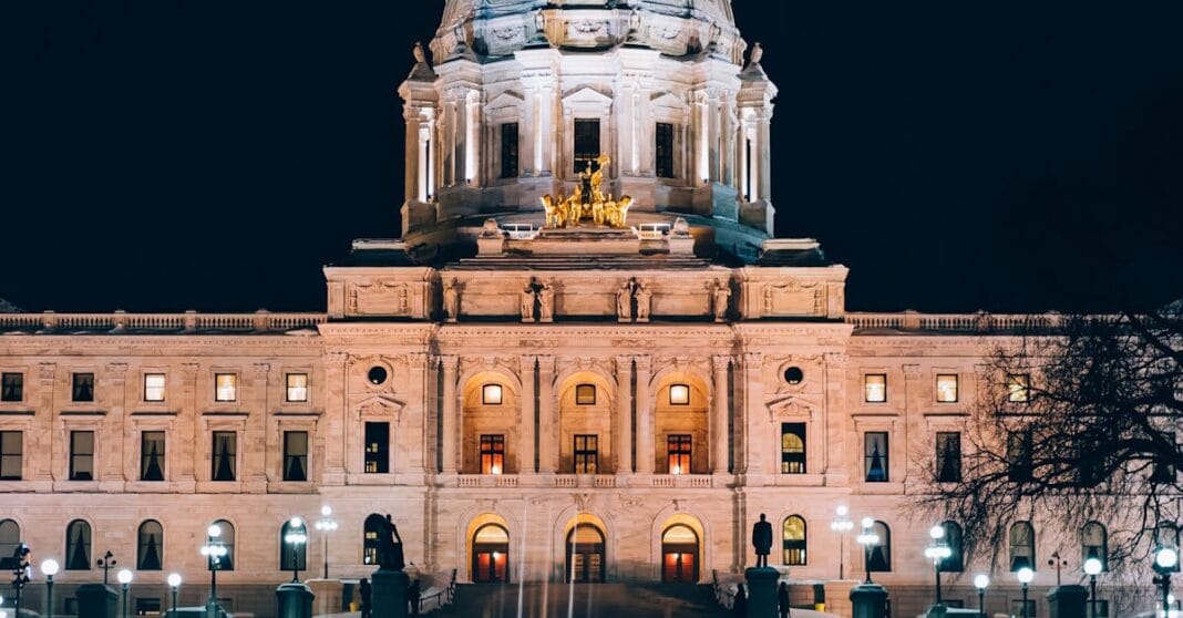 Edifício governamental com cúpula iluminada à noite, em ambiente institucional, evocando poder público, justiça e escrutínio.