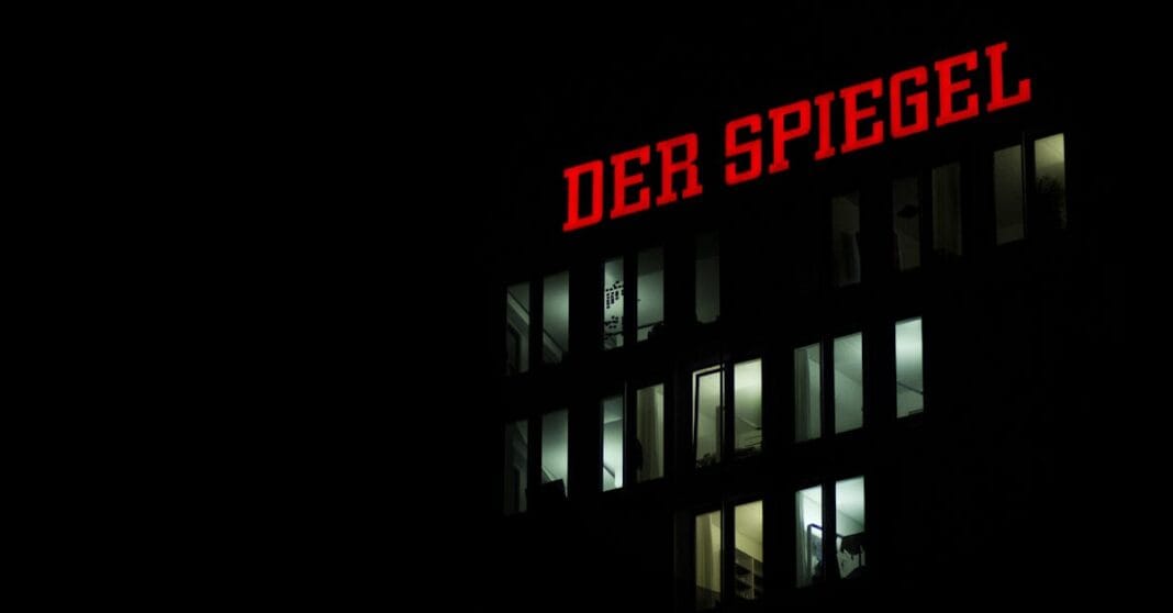 Fachada do edifício do Der Spiegel iluminada à noite em Hamburgo, com o logótipo vermelho destacado no topo.