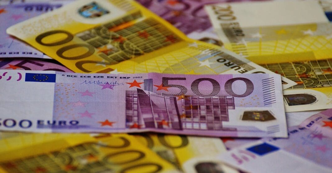 Notas de euro de diferentes valores espalhadas sobre mesa, simbolizando acumulação de riqueza e concentração financeira de bilionários