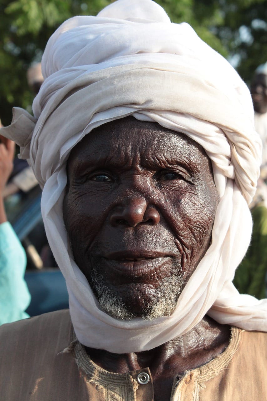 Retrato aproximado de um homem idoso com turbante branco, em luz natural