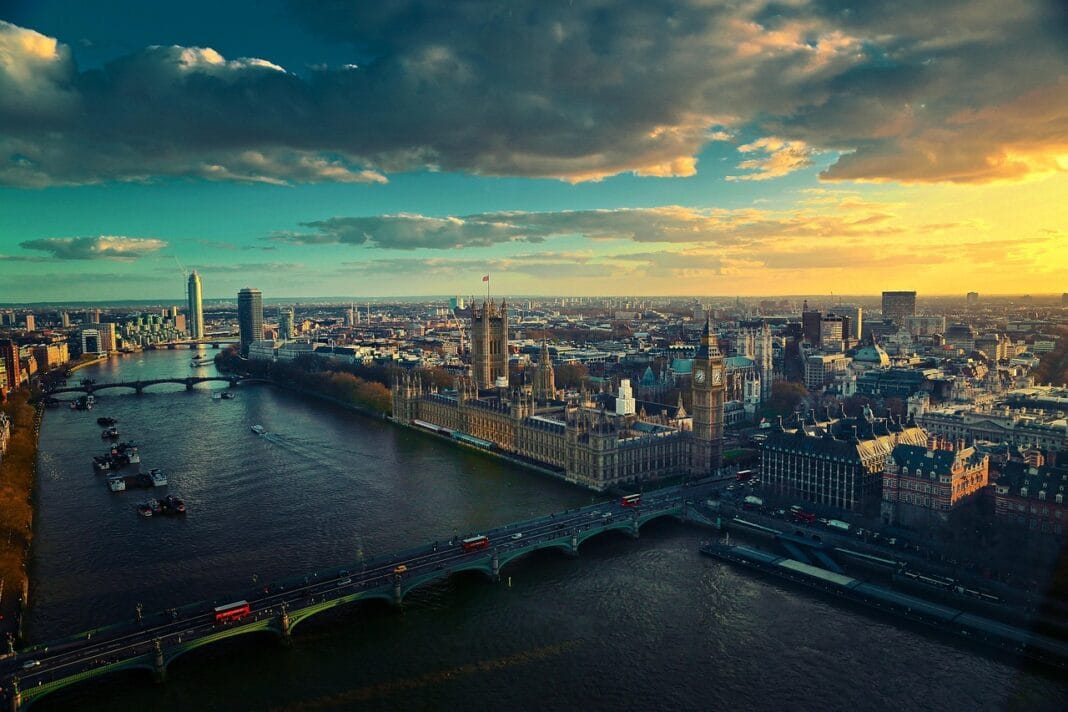 Vista panorâmica de Londres ao pôr do sol, com o rio Tamisa e pontes em primeiro plano.