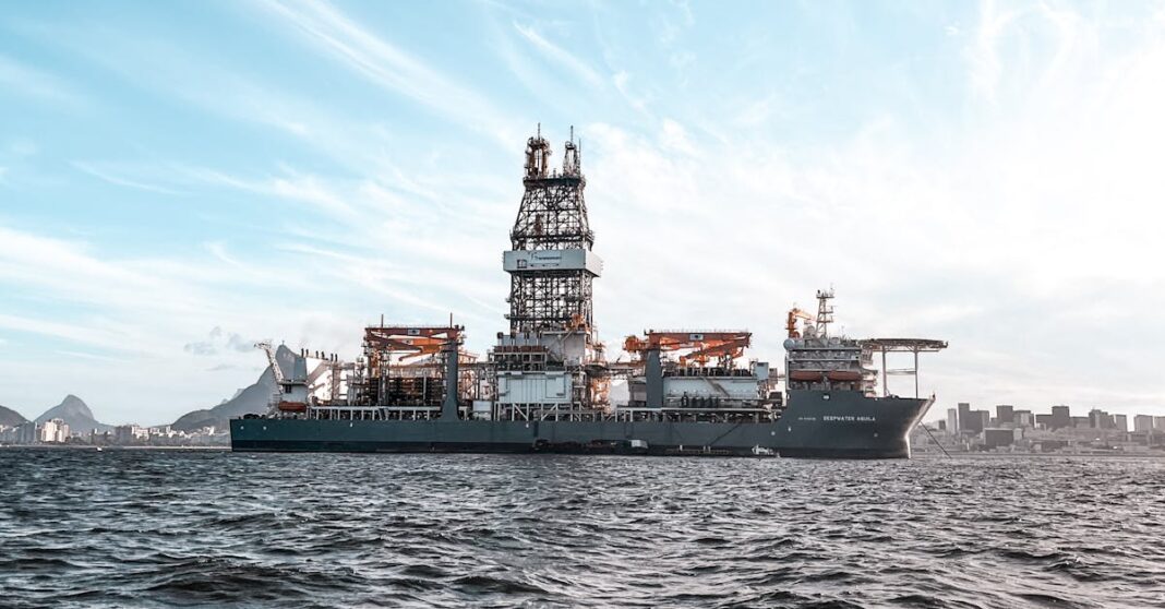 Plataforma de perfuração petrolífera offshore ancorada em águas abertas sob céu encoberto