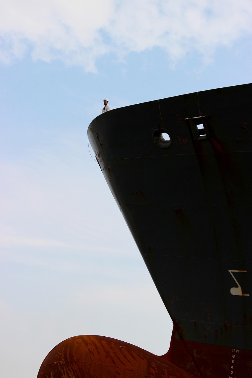Proa de cargueiro negro com um marinheiro no convés superior