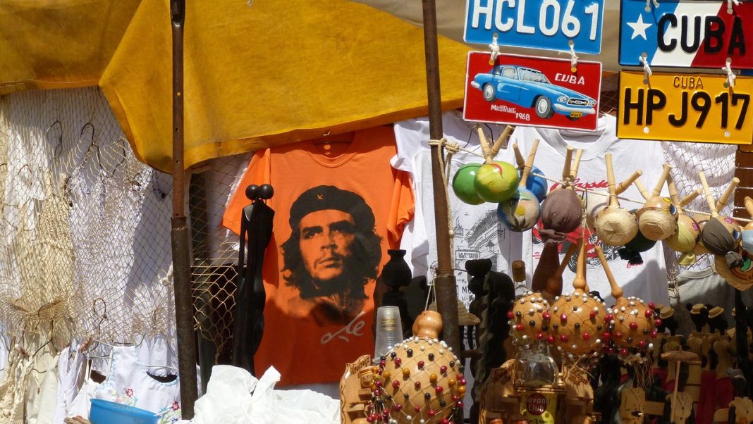 Banca de rua em Cuba com camisolas, matrículas decorativas, artesanato, lembranças turísticas e iconografia política.
