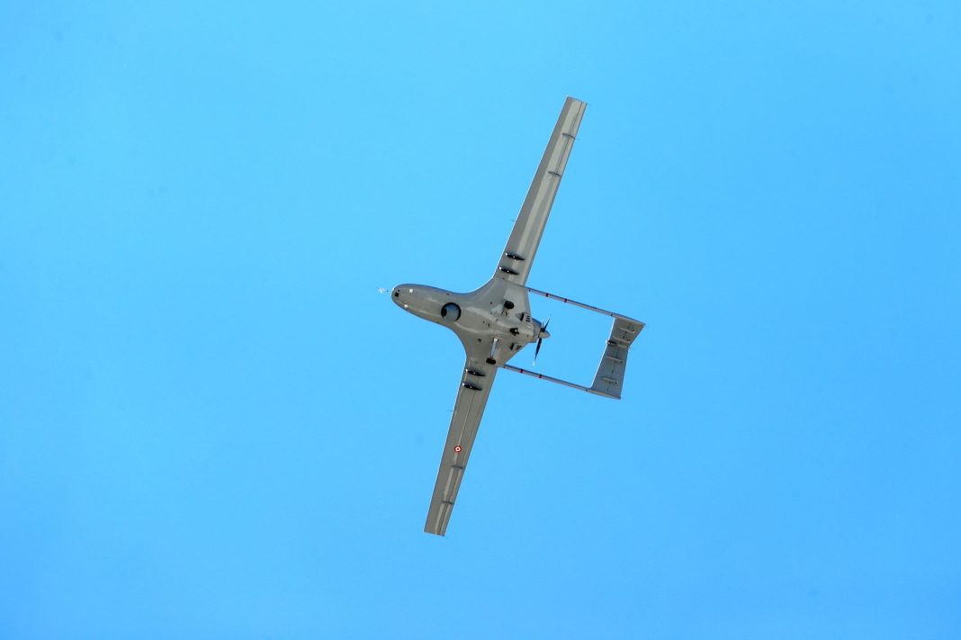 Drone comercial de pequenas dimensões em voo contra um céu limpo e sem nuvens