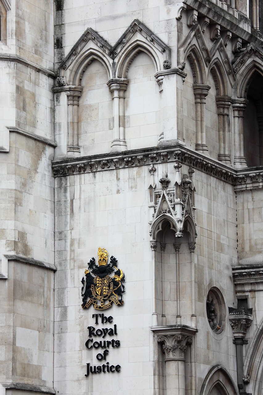 Fachada neogótica dos Royal Courts of Justice, em Londres, com brasão e identificação do tribunal.