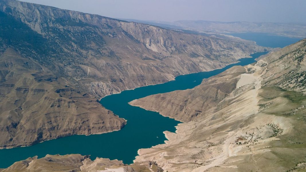 Enseada azul entre montanhas áridas na península de Musandam, em Omã.