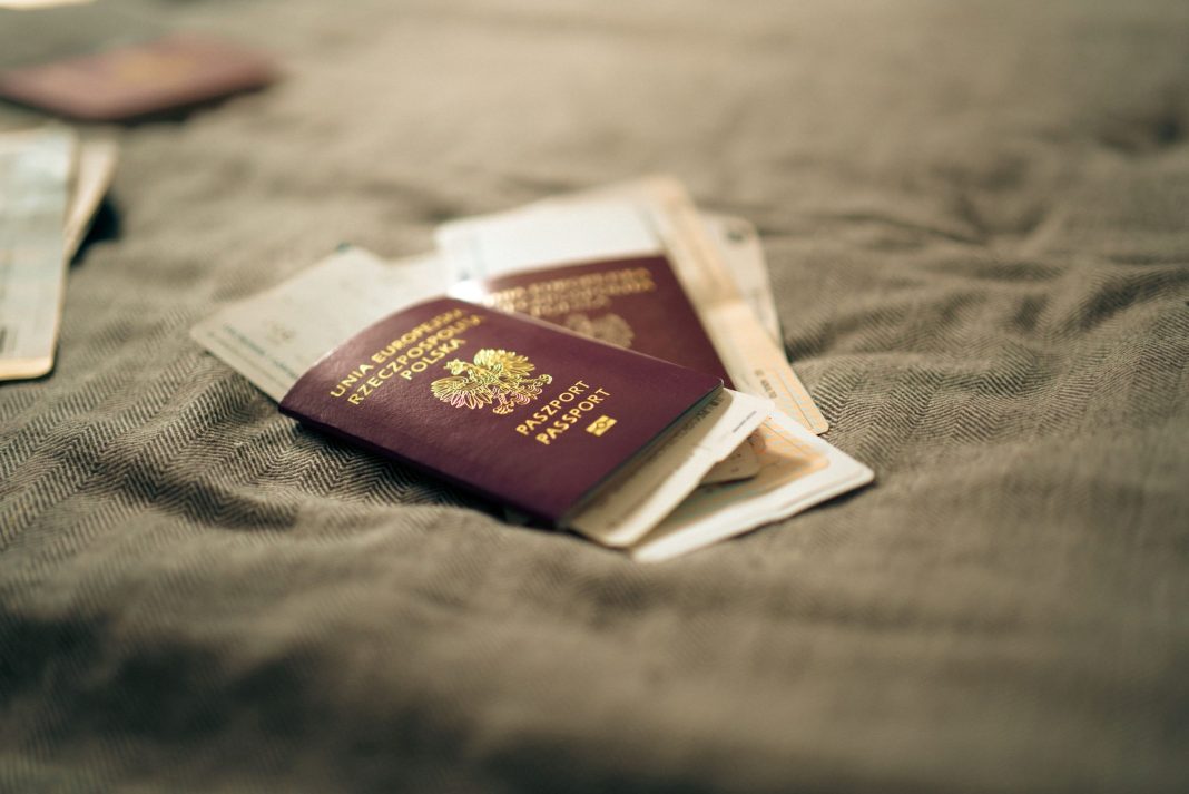 Passaporte sobre um mapa, ilustrando vistos H-1B, mobilidade internacional e contratação de trabalho qualificado.