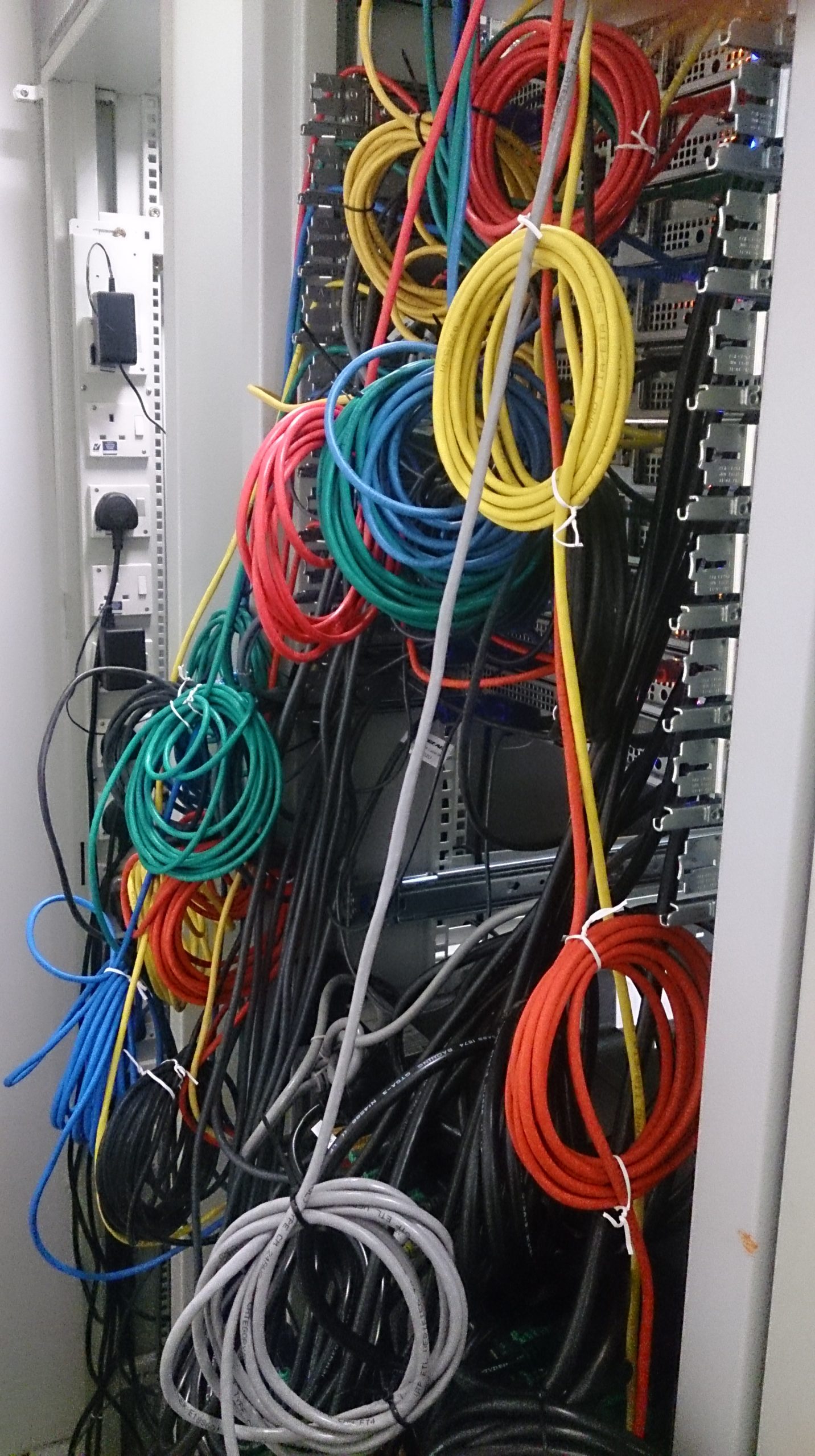 Feixe de cabos de rede ligado a equipamentos numa sala de servidores