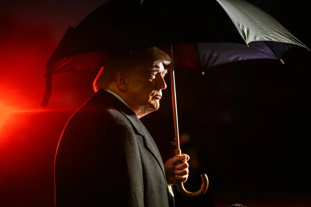 Donald Trump, de perfil e sob um guarda-chuva, no exterior da Casa Branca.