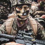 Soldado equipado com uniforme de camuflagem e armamento