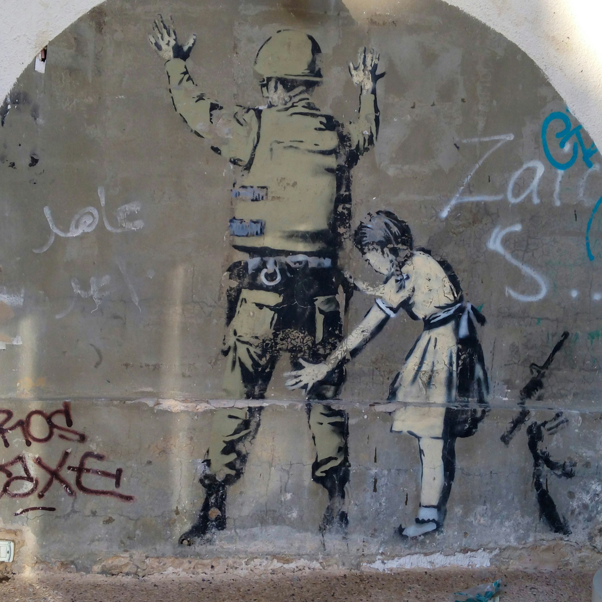 Grafíti de uma rapariga e um soldado num troço do muro de separação em Belém, na Cisjordânia