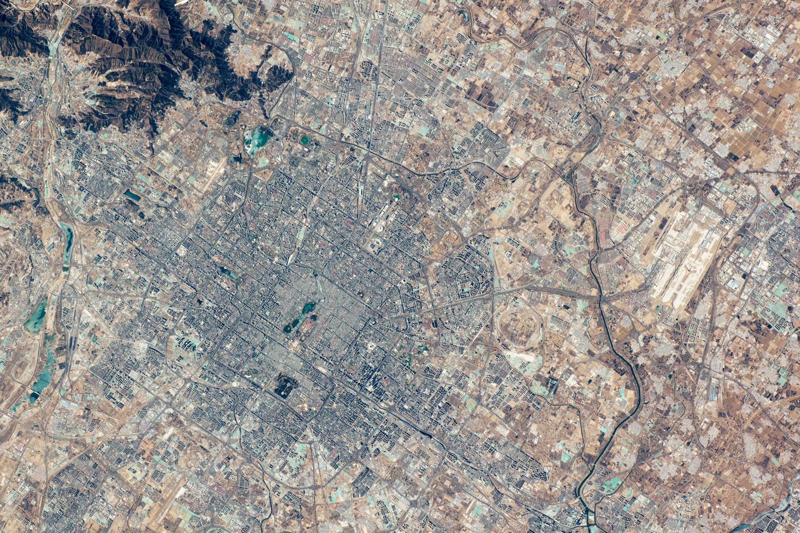 Vista aérea de Pequim a partir da Estação Espacial Internacional, mostrando o traçado dos anéis viários concêntricos e o centro histórico da cidade.