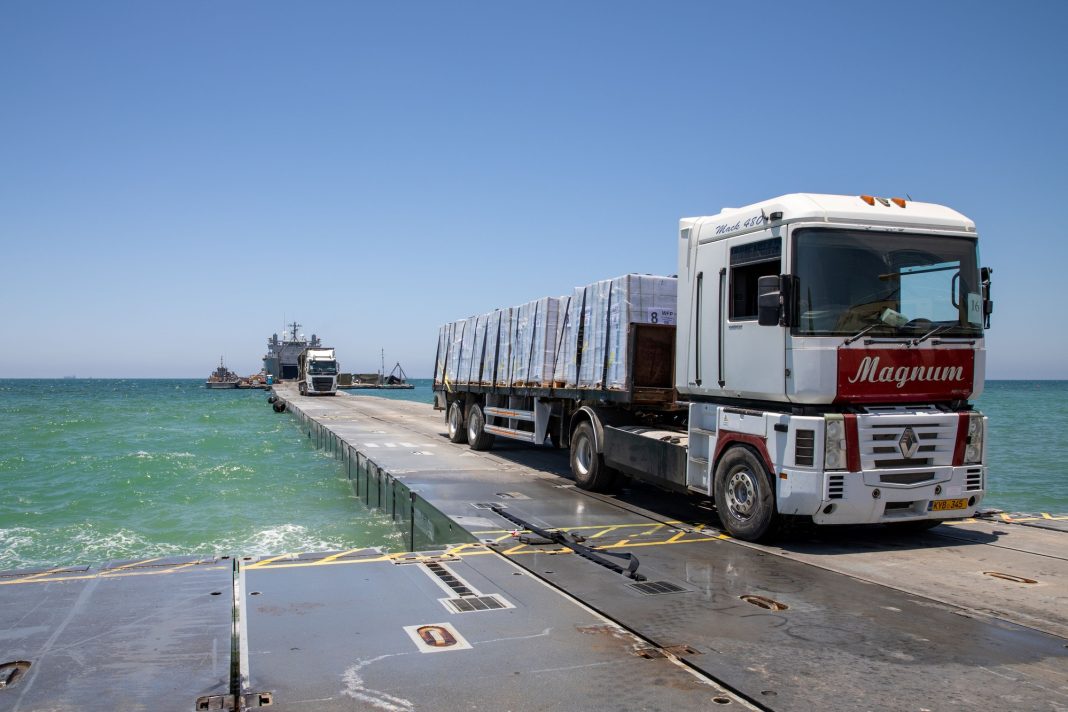 Condutor transporta ajuda humanitária pelo cais temporário Trident Pier até à praia de Gaza