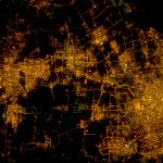 Vista nocturna de Xangai, com os arranha-céus iluminados do distrito de Pudong junto ao rio, fotografada a partir da Estação Espacial Internacional.