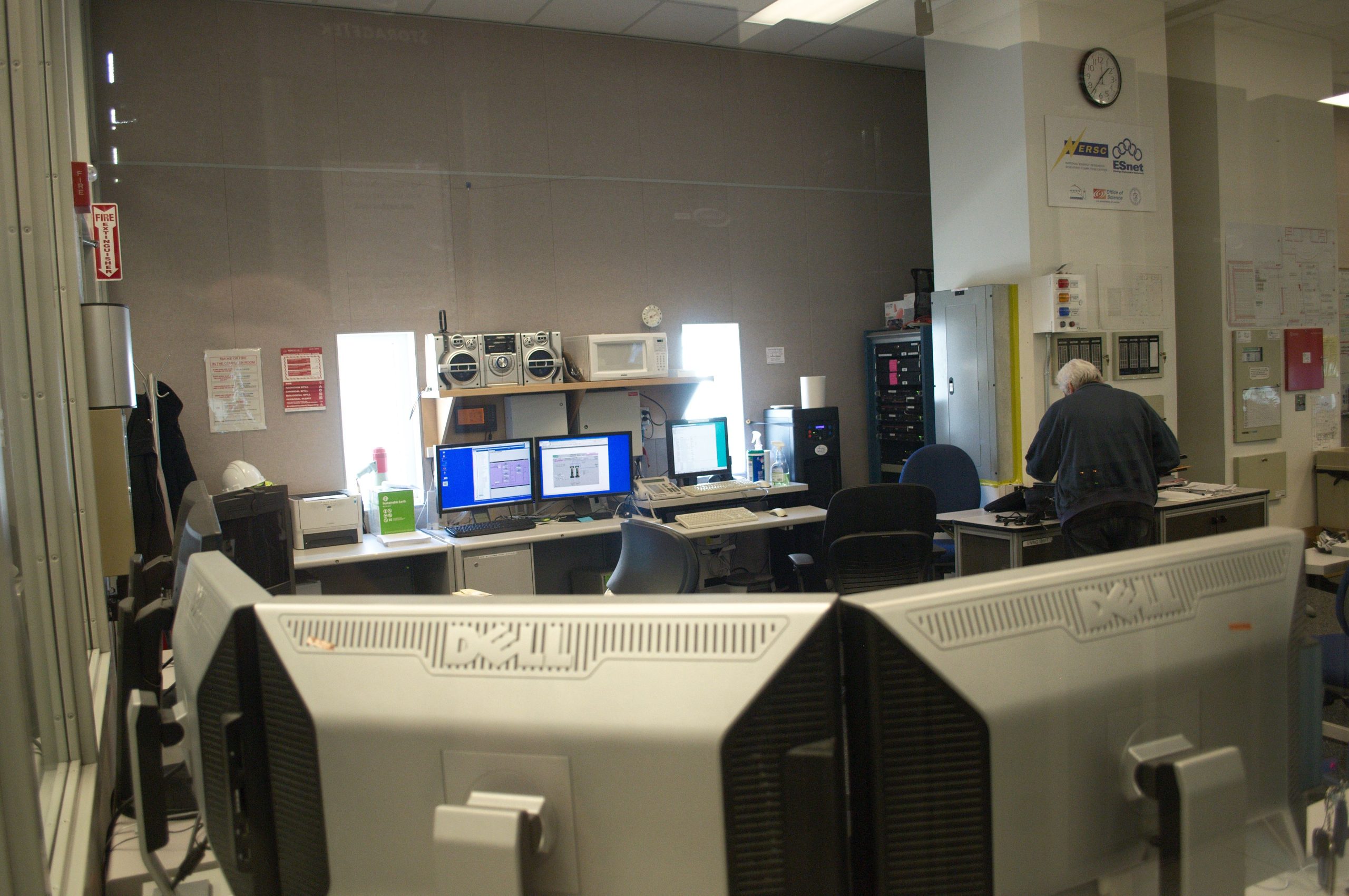 Interior de sala de monitorização informática com técnico