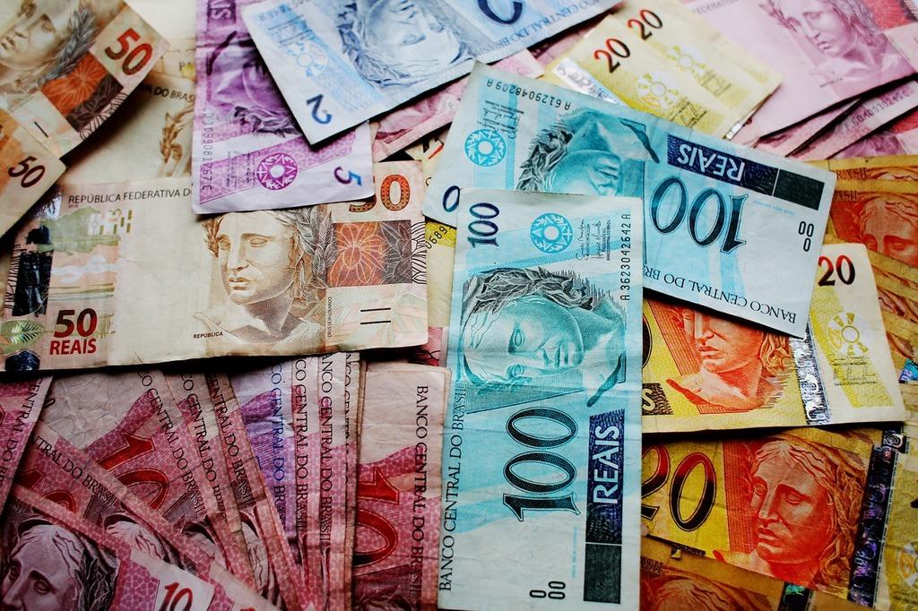 Notas e moedas de reais brasileiros, num artigo sobre a dívida pública