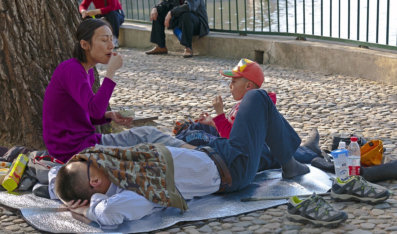 Família com uma criança no Parque Beihai, em Pequim, num artigo sobre natalidade e envelhecimento na China