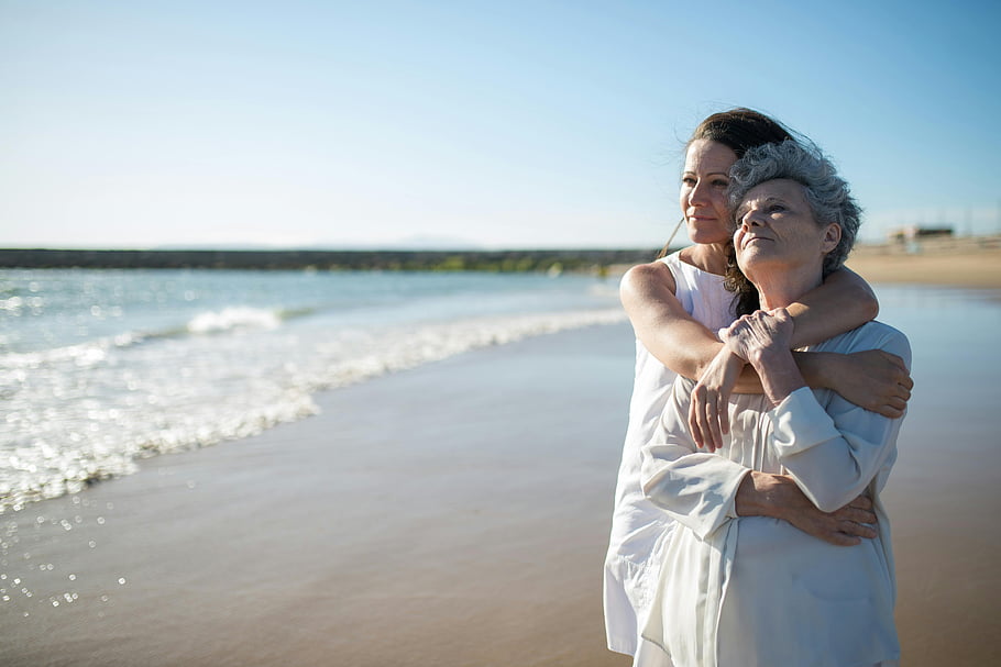Duas mulheres de gerações diferentes numa praia portuguesa, contexto da entreajuda nas famílias monoparentais