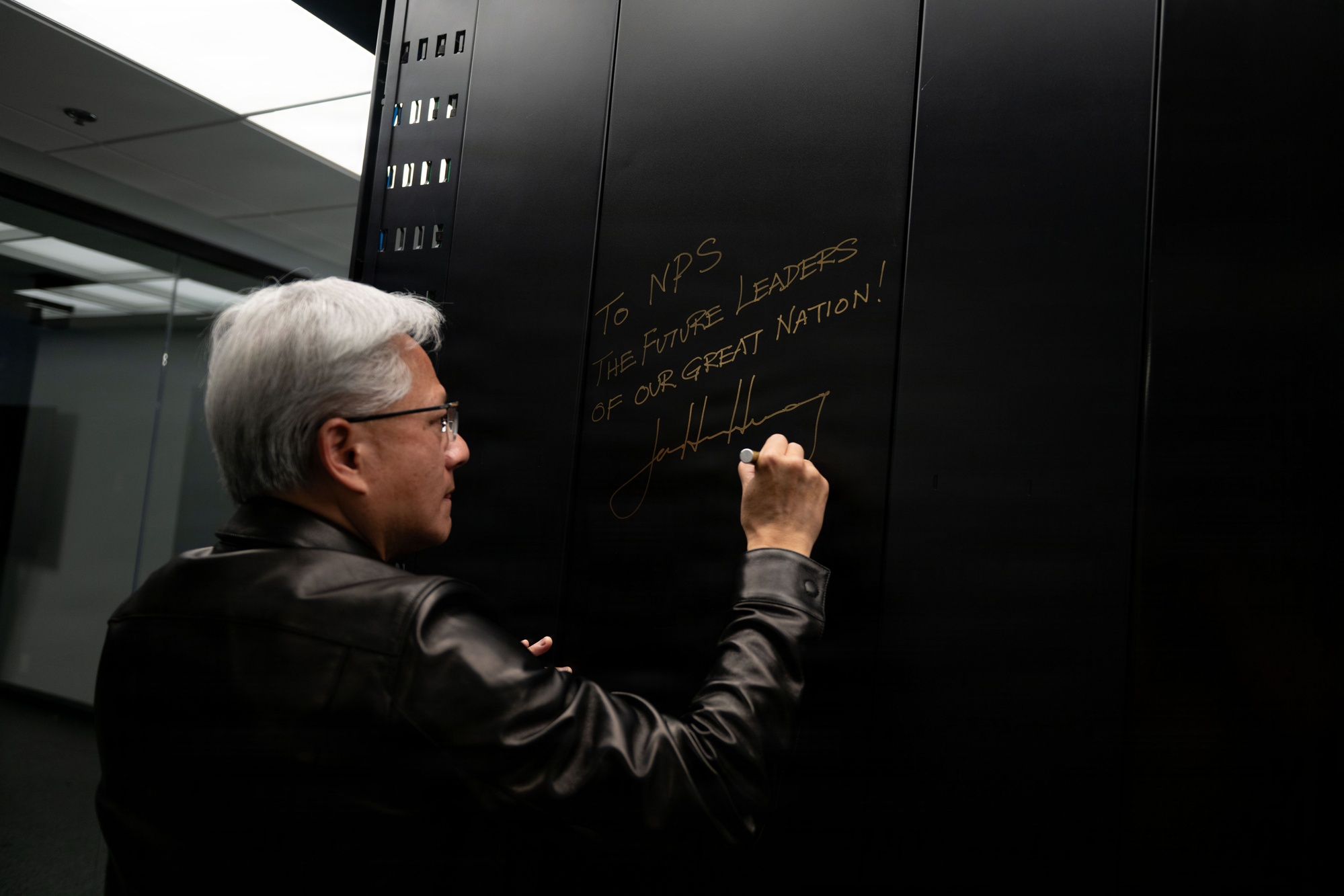 Jensen Huang assina o painel de um NVIDIA DGX GB300, infraestrutura de IA da Naval Postgraduate School