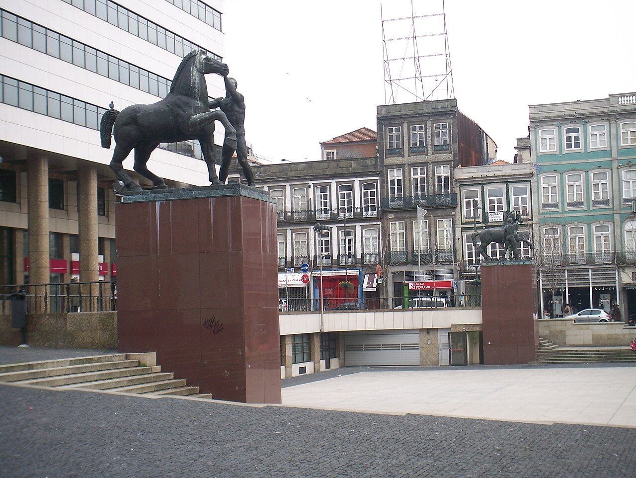 Escultura de um cavalo e edifícios na Praça D. João I, no Porto