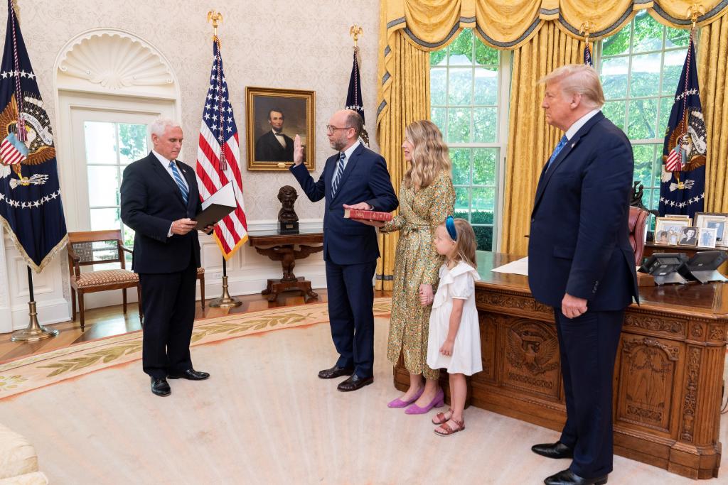 Russell Vought presta juramento perante Mike Pence, com Donald Trump a assistir, na Sala Oval.