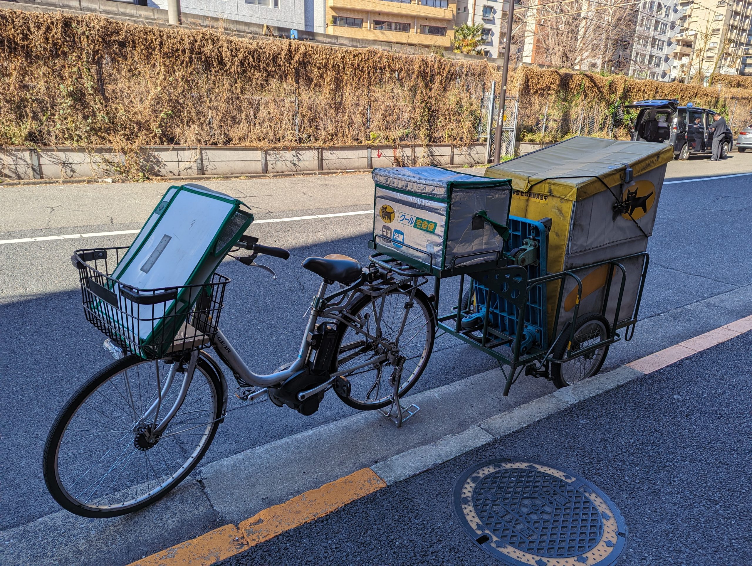 Bicicleta de entregas da Yamato com reboque de carga numa rua de Tóquio