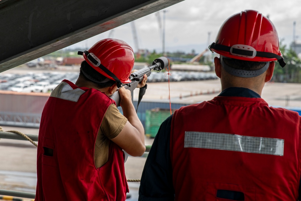 Militares do USS Abraham Lincoln lançam uma linha durante a chegada ao porto de Laem Chabang